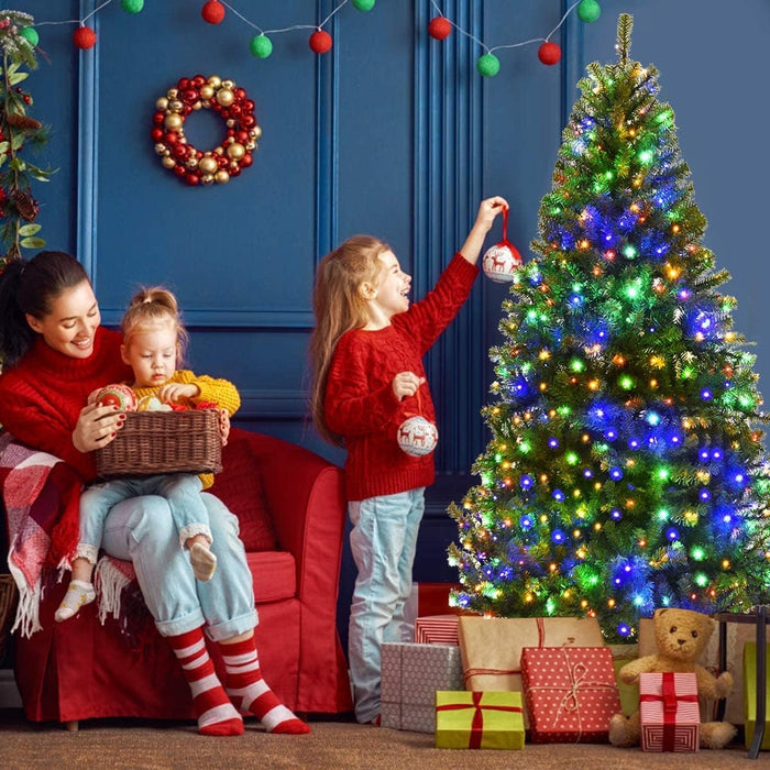 Familj pyntar julgran med inbyggd LED-belysning